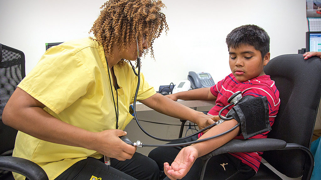 A nurse reading a young boys' blood pressure