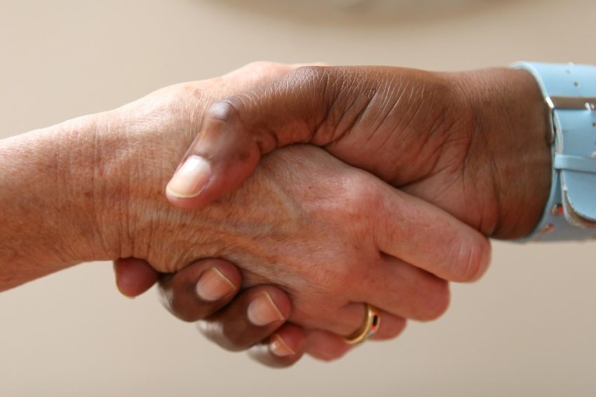 Two hands grasp each other in a handshake