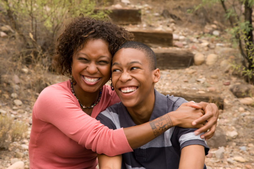 African American mother and son smiling on staircase