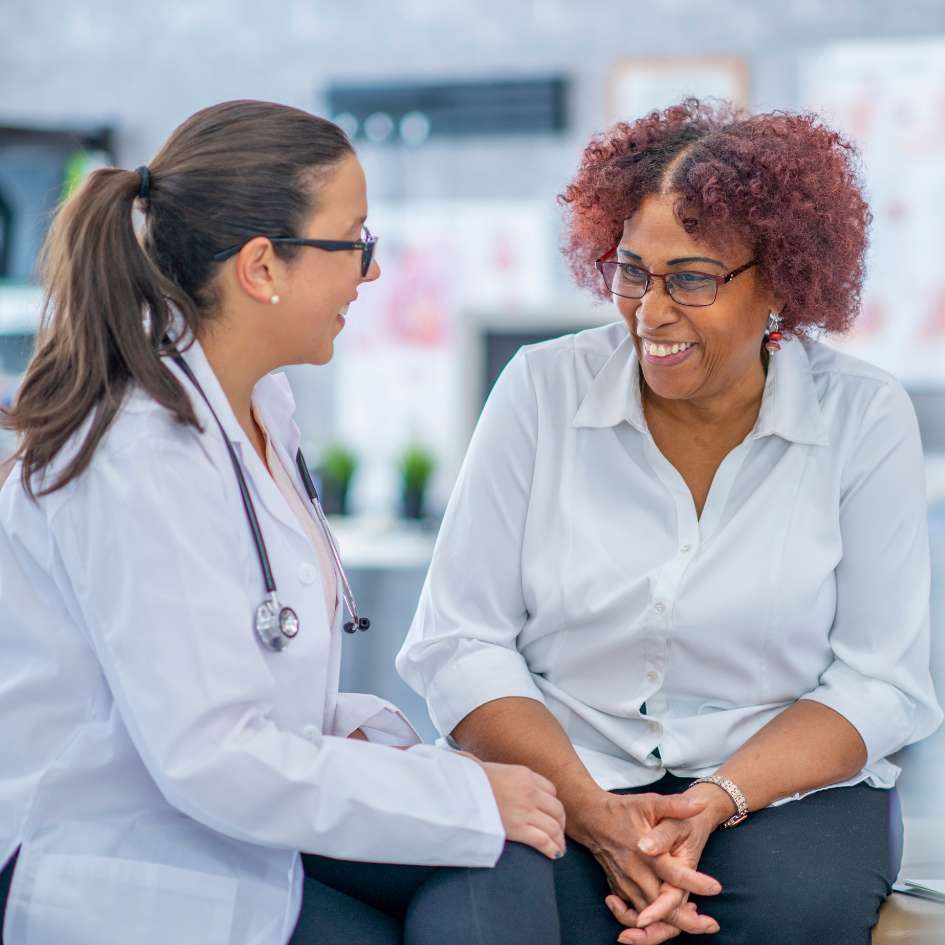 Women talking to doctor both smiling