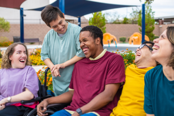 Five young people with disabilities of different races laughing together