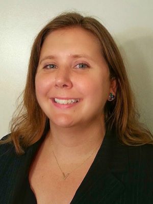 Portrait of Randi Ames, a white woman with blonde hair, in a black shirt against a cream-colored background