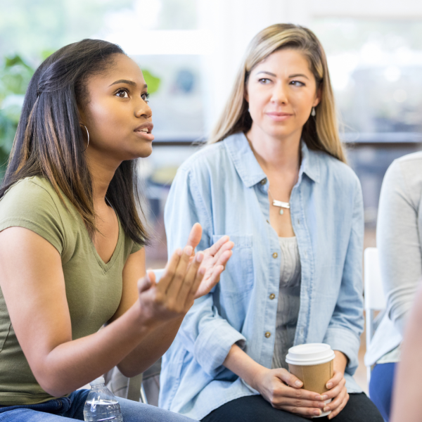 photo of people in group. Young Black woman talking