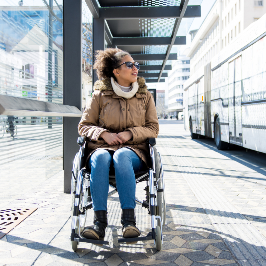 Woman in wheelchair waiting for a bus
