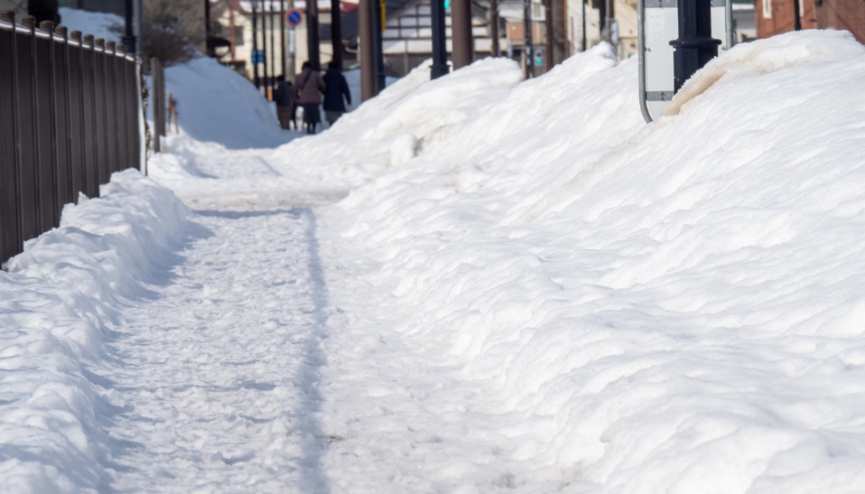 Photo of snow covering a sidewalk.