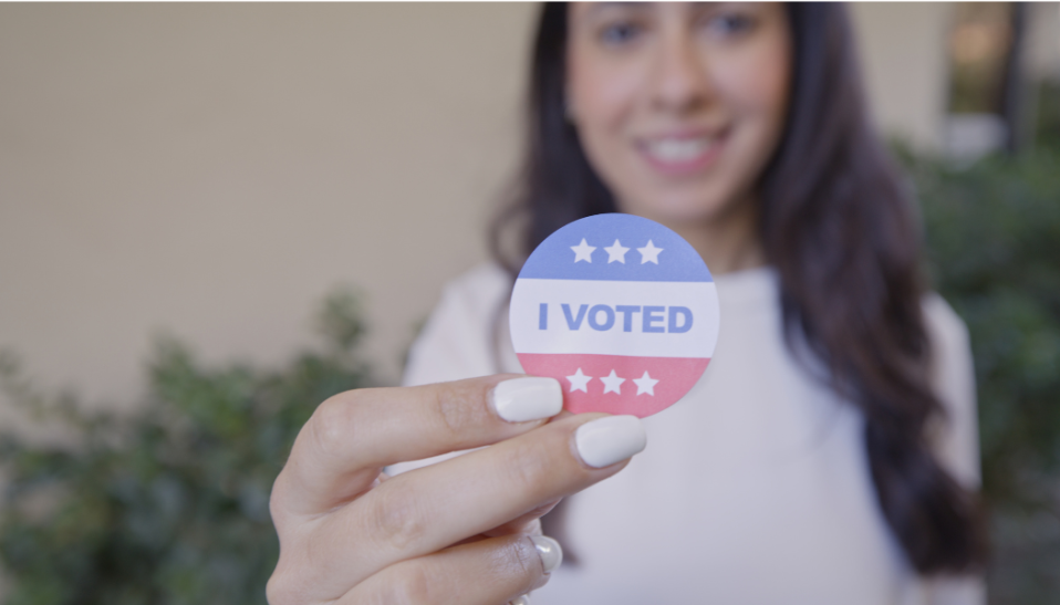 woman holding an "i voted' sticker