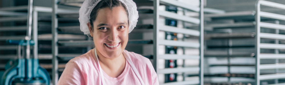 Woman smiling at camera working in a kitchen